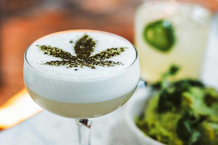 a cocktail with a cannabis leaf design sprinkled on top